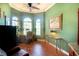 Bright and airy office with hardwood floors, a desk, and a view of the outdoors through arched windows at 2962 Wilderness E Blvd, Parrish, FL 34219