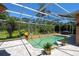 Backyard pool area with screened enclosure and lush tropical landscaping at 2962 Wilderness E Blvd, Parrish, FL 34219