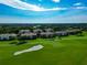 Scenic aerial view of a golf community with sand traps, tree-lined streets, and well-kept lawns at 318 Winding Brook Ln # 104, Bradenton, FL 34212