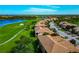 Stunning aerial view of a community with a golf course, lake, and tree-lined streets at 318 Winding Brook Ln # 104, Bradenton, FL 34212