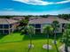 Lush green lawn with palm trees lining the yard of this building with screened lanais and mature trees at 318 Winding Brook Ln # 104, Bradenton, FL 34212