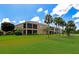 Spacious backyard featuring a well-maintained lawn near a building with screened lanais and swaying palm trees at 318 Winding Brook Ln # 104, Bradenton, FL 34212