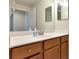 Bathroom featuring vanity with large mirror, spacious countertop, and wood cabinets at 318 Winding Brook Ln # 104, Bradenton, FL 34212