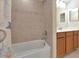Bathroom featuring shower over bath, tiled walls, vanity with storage at 318 Winding Brook Ln # 104, Bradenton, FL 34212