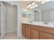 Bright bathroom with dual sinks, wood cabinets, and neutral decor at 318 Winding Brook Ln # 104, Bradenton, FL 34212