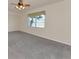 Neutral bedroom with large window, ceiling fan, and plush gray carpet at 318 Winding Brook Ln # 104, Bradenton, FL 34212