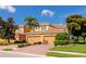 Charming two-story townhome with tile roof, attached garages, manicured landscaping, and a brick driveway at 318 Winding Brook Ln # 104, Bradenton, FL 34212