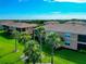 Exterior view of condos featuring screened lanais, palm trees, and lush green lawns at 318 Winding Brook Ln # 104, Bradenton, FL 34212