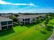 Exterior view of condos with screened lanais, lush lawns, and palm trees enhancing the landscape at 318 Winding Brook Ln # 104, Bradenton, FL 34212