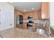 Well-equipped kitchen with stainless steel appliances and granite countertops; breakfast bar overlooks an adjacent room at 318 Winding Brook Ln # 104, Bradenton, FL 34212