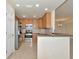 Modern kitchen with stainless steel appliances, wood cabinets, granite countertops, and tiled floor at 318 Winding Brook Ln # 104, Bradenton, FL 34212