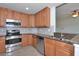 Stylish kitchen with stainless steel appliances, wood cabinets, granite counters, and tiled floors at 318 Winding Brook Ln # 104, Bradenton, FL 34212