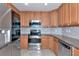 Open kitchen with stainless steel appliances, ample wood cabinets, granite counters, and tiled floor at 318 Winding Brook Ln # 104, Bradenton, FL 34212