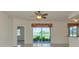Bright living room with ceiling fan and sliding glass doors leading to a screened lanai overlooking a lush, green view at 318 Winding Brook Ln # 104, Bradenton, FL 34212
