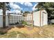 View of the backyard with raised garden beds, a storage shed, and fresh mulch at 327 Francis Dr, Apollo Beach, FL 33572
