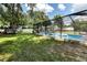 Spacious backyard featuring a screened-in pool, green lawn, and shade trees at 327 Francis Dr, Apollo Beach, FL 33572