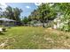 Expansive backyard with lush green grass, pool with screen, and shed with garden at 327 Francis Dr, Apollo Beach, FL 33572