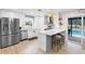 Modern kitchen featuring stainless steel appliances, a stylish island with seating, and easy access to the pool area at 327 Francis Dr, Apollo Beach, FL 33572