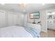 Relaxing main bedroom featuring a mounted television, white dresser, and an ensuite bathroom at 327 Francis Dr, Apollo Beach, FL 33572