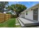 Cozy backyard featuring a wooden deck, privacy fence, and mature tree providing shade at 3310 W 9Th Ave, Bradenton, FL 34205