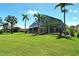 Beautiful home and in-ground pool with screened in lanai with lush grass and palm trees at 340 Bermuda Ct # 5, Venice, FL 34293