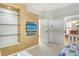 Modern bedroom boasts a TV wall with floating glass shelves and an open doorway into the dining room at 340 Bermuda Ct # 5, Venice, FL 34293