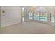 Bedroom with carpet, arched windows with plantation shutters, and view of the pool area at 340 Bermuda Ct # 5, Venice, FL 34293