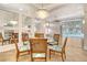 Bright dining area with chandelier, decorative mirror and view of pool area at 340 Bermuda Ct # 5, Venice, FL 34293
