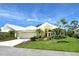Inviting yellow single-Gathering home with white roof, lush lawn, and tropical landscaping at 340 Bermuda Ct # 5, Venice, FL 34293