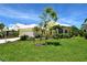 Inviting yellow single-Gathering home with white roof, lush lawn, and tropical landscaping at 340 Bermuda Ct # 5, Venice, FL 34293