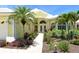 Beautiful yellow home exterior with tropical landscaping, stone walkway and double door entry at 340 Bermuda Ct # 5, Venice, FL 34293