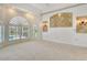 Bedroom with carpet, tray ceiling, arched windows with plantation shutters, and decorative sconces at 340 Bermuda Ct # 5, Venice, FL 34293