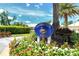 Bermuda Club West community sign surrounded by lush tropical foliage and colorful flowers at 340 Bermuda Ct # 5, Venice, FL 34293