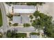 Bird's eye view of residential buildings with gray roofs and surrounding green trees near paved road at 3720 Gulf Dr, Holmes Beach, FL 34217