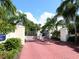 Elegant gated entrance with lush landscaping and red brick pathway leading to the community at 3954 Hamilton Club Cir # 14, Sarasota, FL 34242