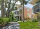 Multi-story home with a beautiful garden featuring tropical landscaping and an elegant exterior staircase at 3954 Hamilton Club Cir # 14, Sarasota, FL 34242