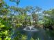 Exterior of a three-story building set among lush landscaping and a fountain pond at 3954 Hamilton Club Cir # 14, Sarasota, FL 34242