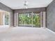 Bright living room with neutral carpet, decorative wallpaper, and sliding glass doors to the balcony at 3954 Hamilton Club Cir # 14, Sarasota, FL 34242