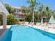 Refreshing pool with clear blue water, surrounded by lounge chairs, tables, and lush tropical landscaping at 3954 Hamilton Club Cir # 14, Sarasota, FL 34242