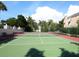 Well-maintained tennis court under a sunny sky, surrounded by lush tropical greenery and elegant residences at 3954 Hamilton Club Cir # 14, Sarasota, FL 34242