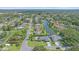 An aerial view shows many homes alongside a waterway, with abundant trees, grass, and landscaping at 4396 Pasadena Cir, Sarasota, FL 34233