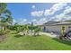 Green backyard with a pool, lounge chairs, and tropical landscaping under a sunny sky at 4396 Pasadena Cir, Sarasota, FL 34233