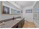 Bathroom featuring granite counters, wood-look flooring, and glass-enclosed tub at 4396 Pasadena Cir, Sarasota, FL 34233