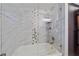 Bathroom featuring a bathtub and shower with a tile surround and glass door at 4396 Pasadena Cir, Sarasota, FL 34233