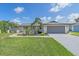 Charming single-story home featuring a gray roof, a two-car garage, and lush landscaping at 4396 Pasadena Cir, Sarasota, FL 34233