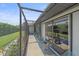 View of the screened lanai overlooking the backyard with mature landscaping and chairs to relax at 4396 Pasadena Cir, Sarasota, FL 34233