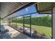 View of screened lanai overlooking the green backyard with mature hedges and landscaping at 4396 Pasadena Cir, Sarasota, FL 34233
