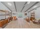 Bright living room with neutral walls, beamed ceilings, and wood-look tile floors that flow into dining area at 4396 Pasadena Cir, Sarasota, FL 34233
