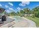 Backyard pool with seating and an umbrella and outdoor grill surrounded by well-maintained landscaping at 4396 Pasadena Cir, Sarasota, FL 34233