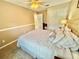 A bright, carpeted bedroom with a tufted headboard and an ensuite bathroom at 4716 98Th E Ter, Parrish, FL 34219